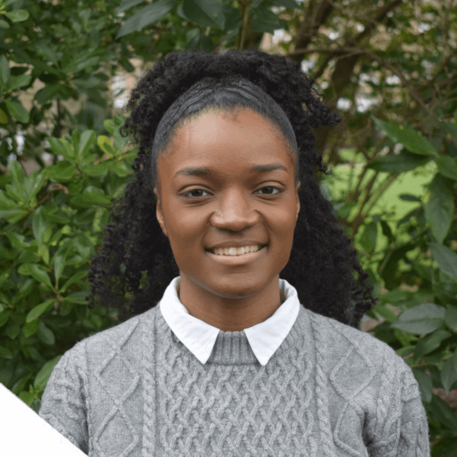 A photo of Imaan Wright - a staff member at Money and Mental Health. Imaan is smiling while standing in front of some trees.