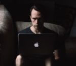 Man sitting in darkness on laptop