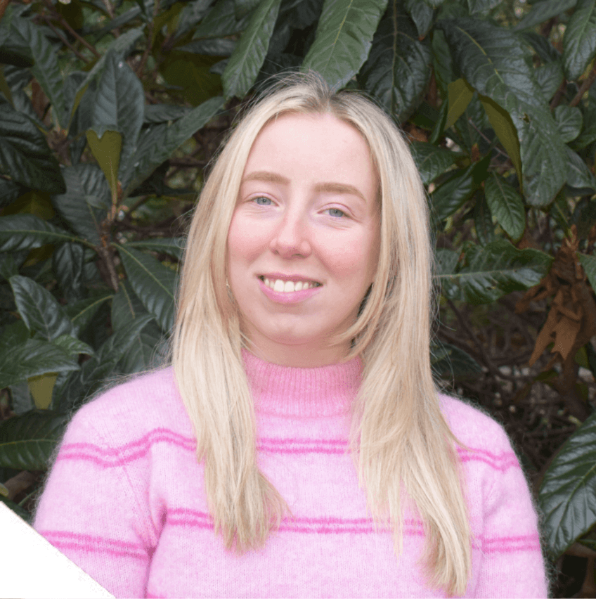 A photo of Francesca Smith - a staff member at Money and Mental Health. Francesca is smiling while standing in front of a tree.