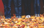 Photo of four people standing against a wall