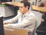 Photo of man at desk for workplace wellbeing report