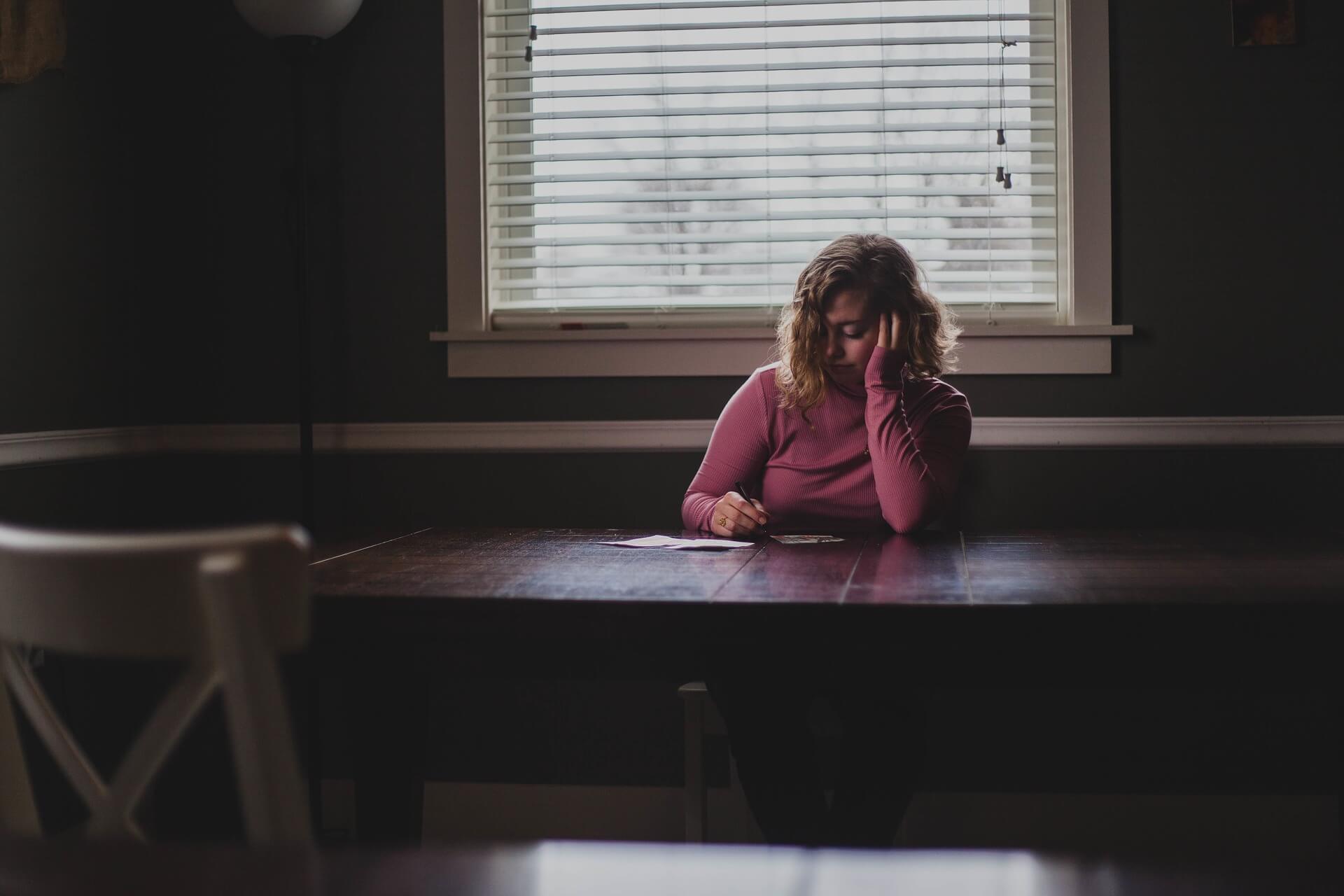 woman sitting at table looking worried