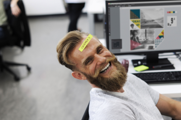 Man smiling at desk for fintech and mental health blog