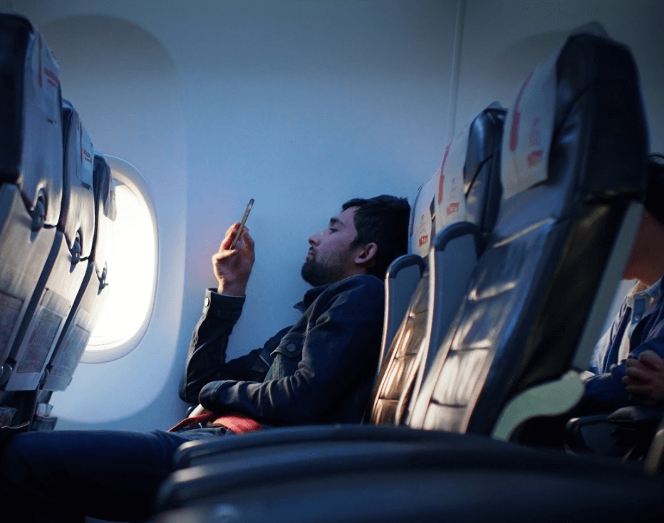 A man sitting on a plane by the window seat