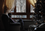 Photo of man reading by a tree for money worries at christmas blog