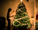 Woman decorating christmas tree for money worries at christmas blog
