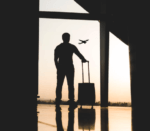 Man standing looking at plane taking off