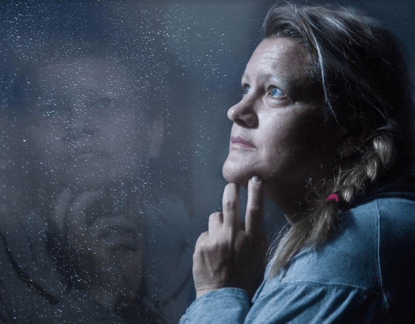 Recovery space image of woman looking out of window