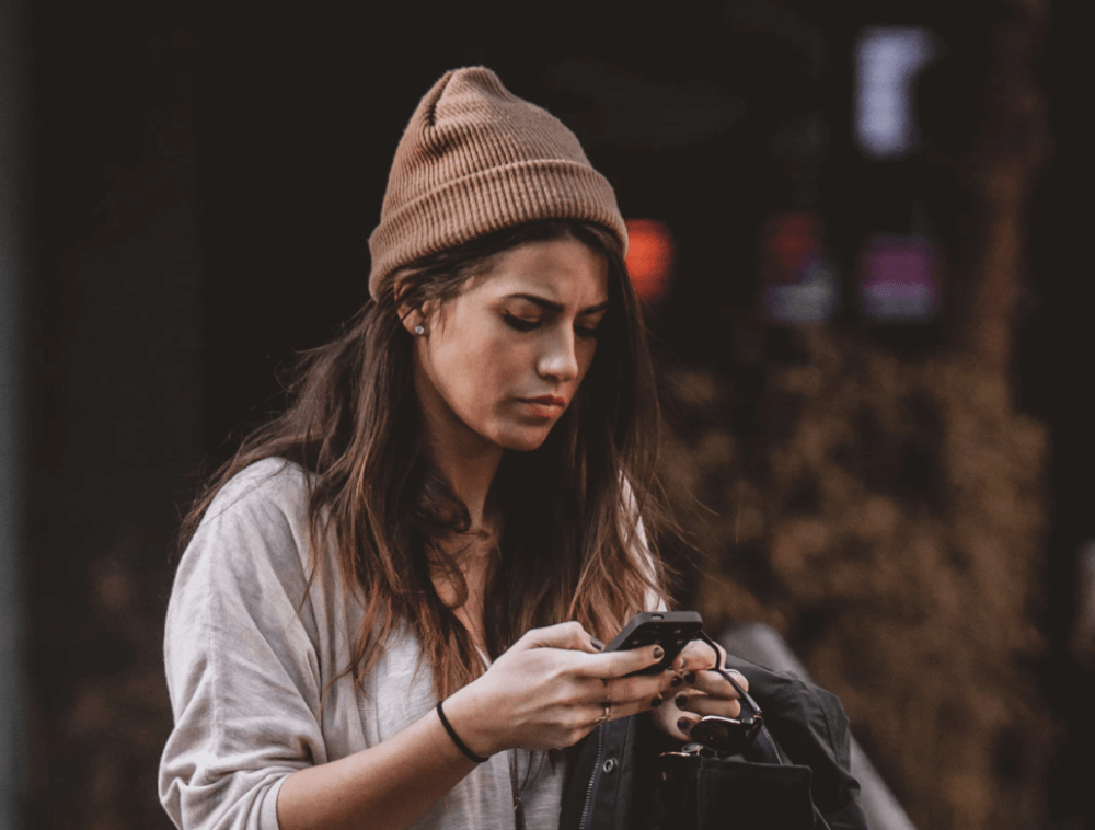 Image of woman frowning at phone for high-cost short-term credit blog