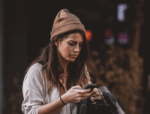 Image of woman frowning at phone for high-cost short-term credit blog