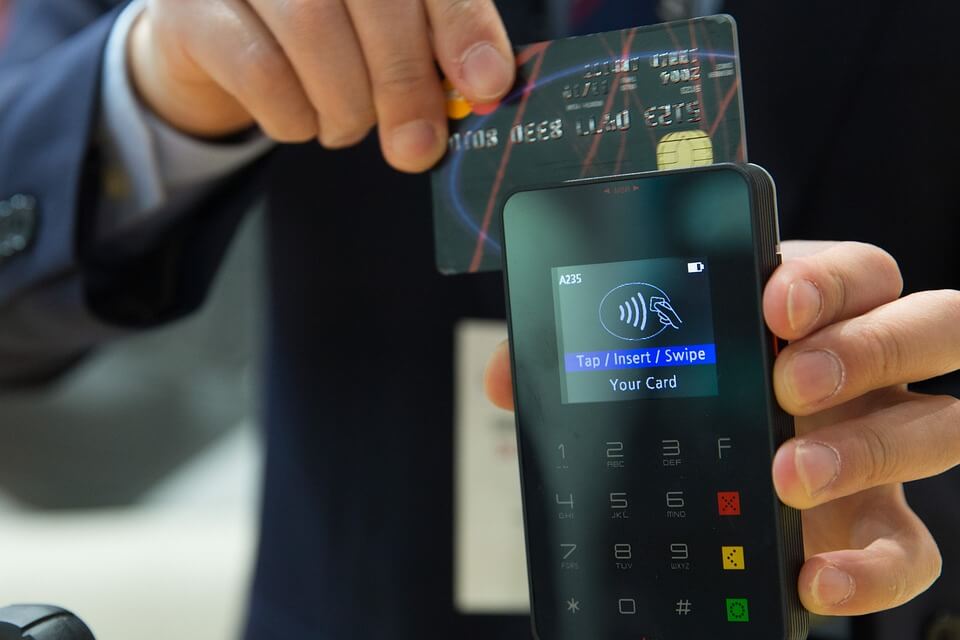 An image of a man making a payment with his bank card