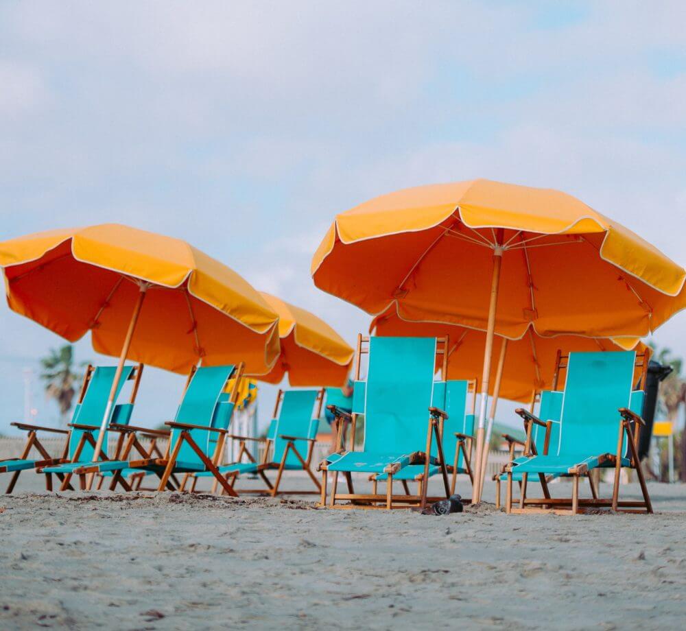 beach chairs on the sand with umbrella