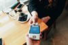 person paying with their card in a chip and pin machine in a cafe