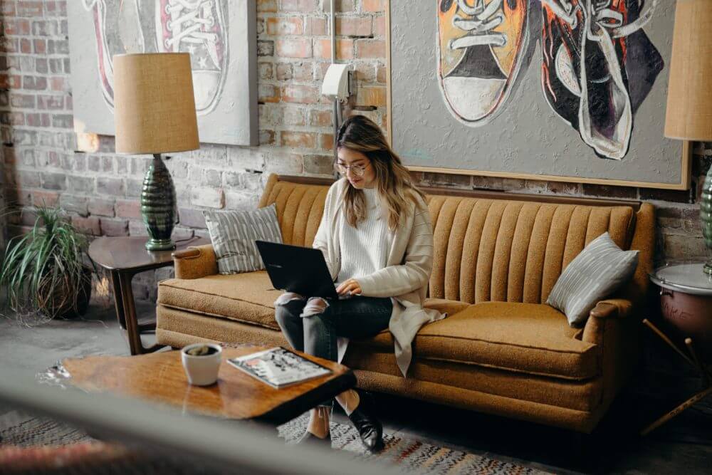 woman sitting on laptop in her living room