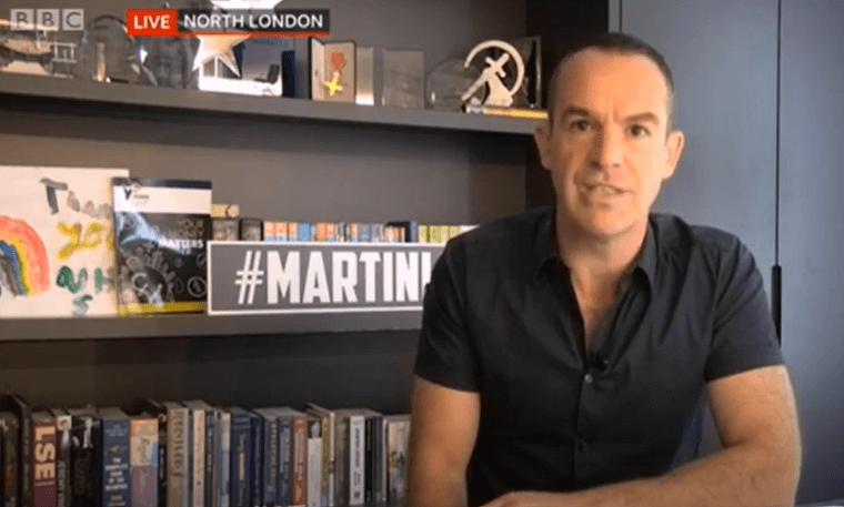 Martin Lewis sits in front of a bookshelf