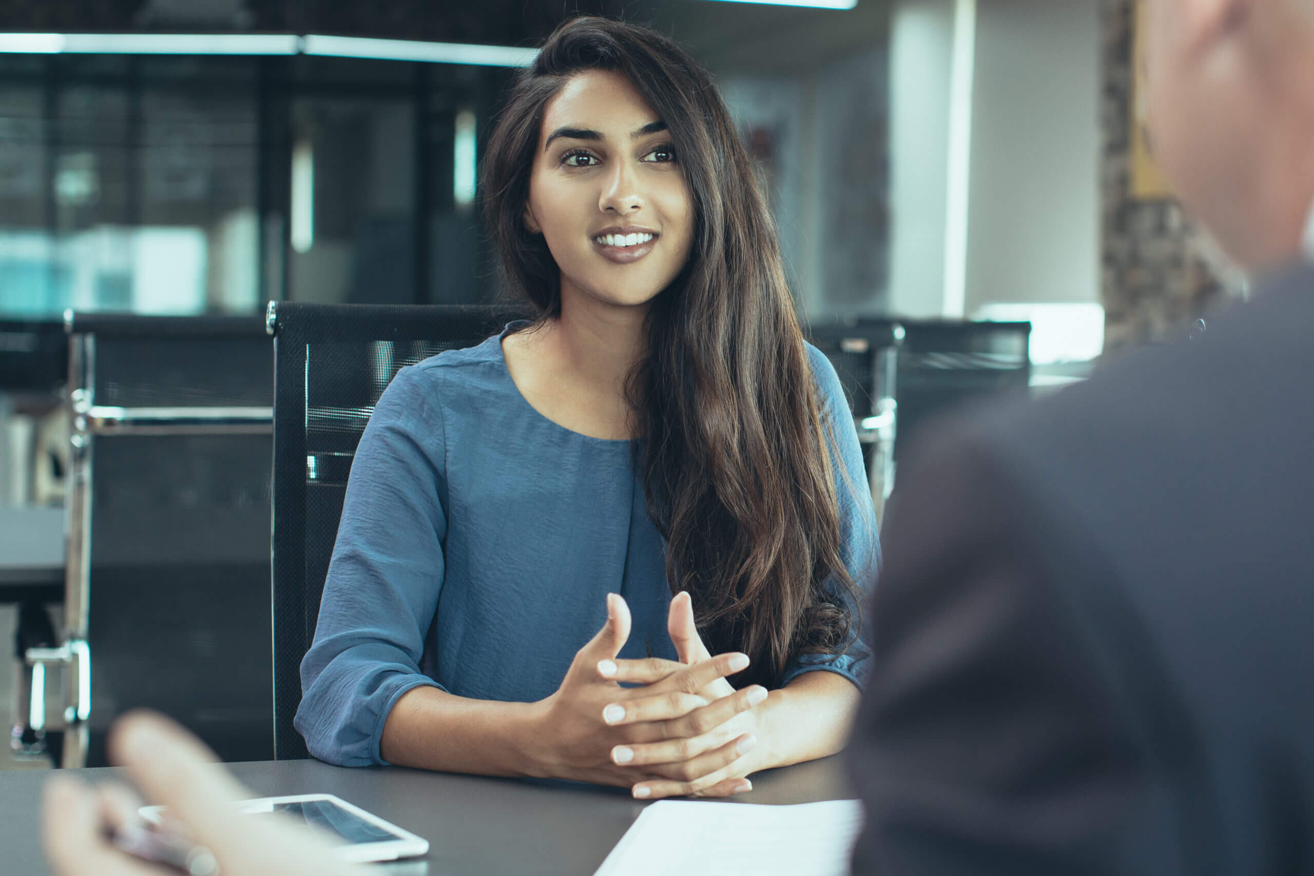 Woman sitting down at table for interview
