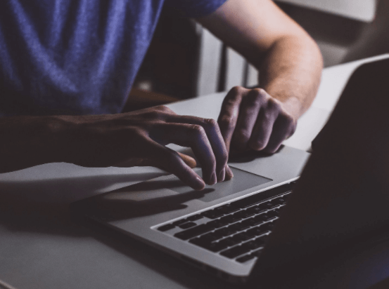 man using a laptop in a darkened room