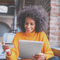 Woman looking at ipad and holding bank card