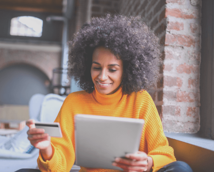 Woman looking at ipad and holding bank card