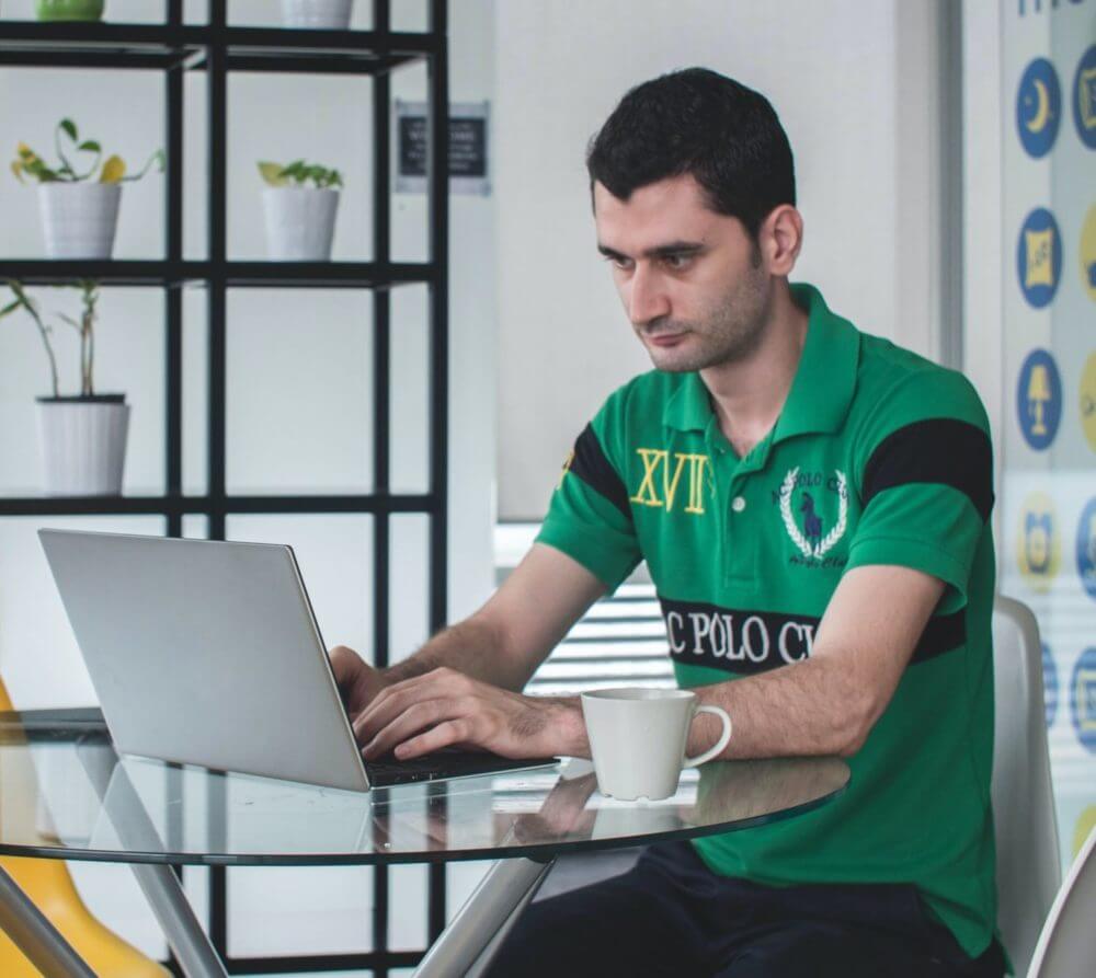 man at kitchen table on laptop