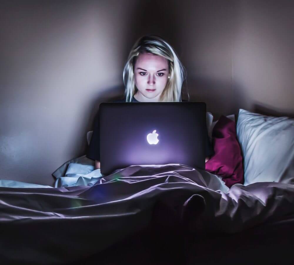 person in dark room on laptop