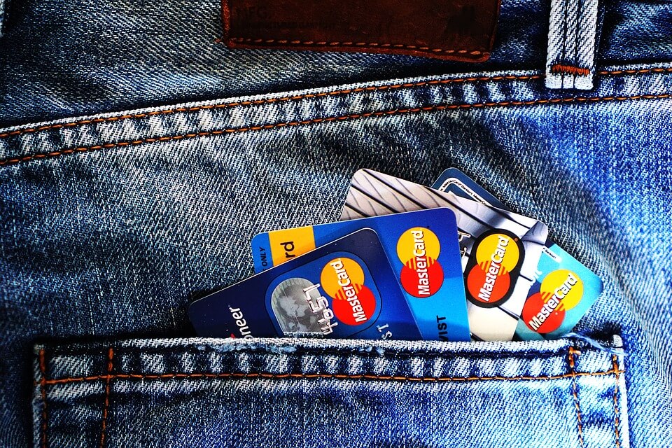 The back pocket of a pair of jeans, full of credit or debit cards.