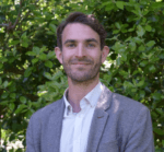 Photo of Brian Semple standing in front of greenery