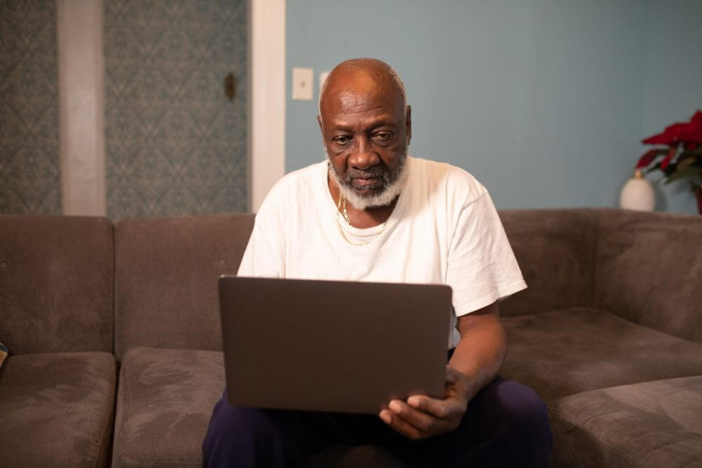 man on laptop sitting on the sofa