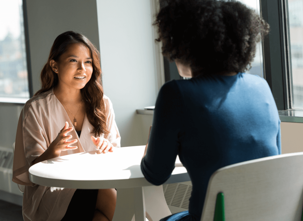 Two people in conversation in a workplace setting