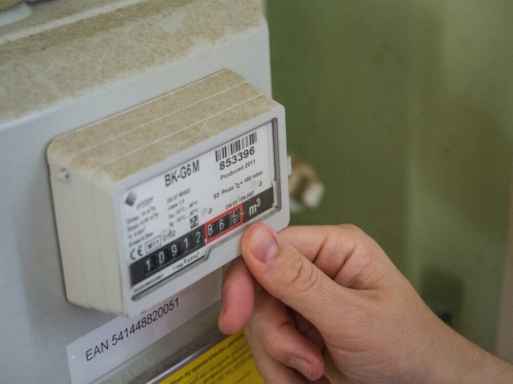 A person's hand on a pre-payment meter