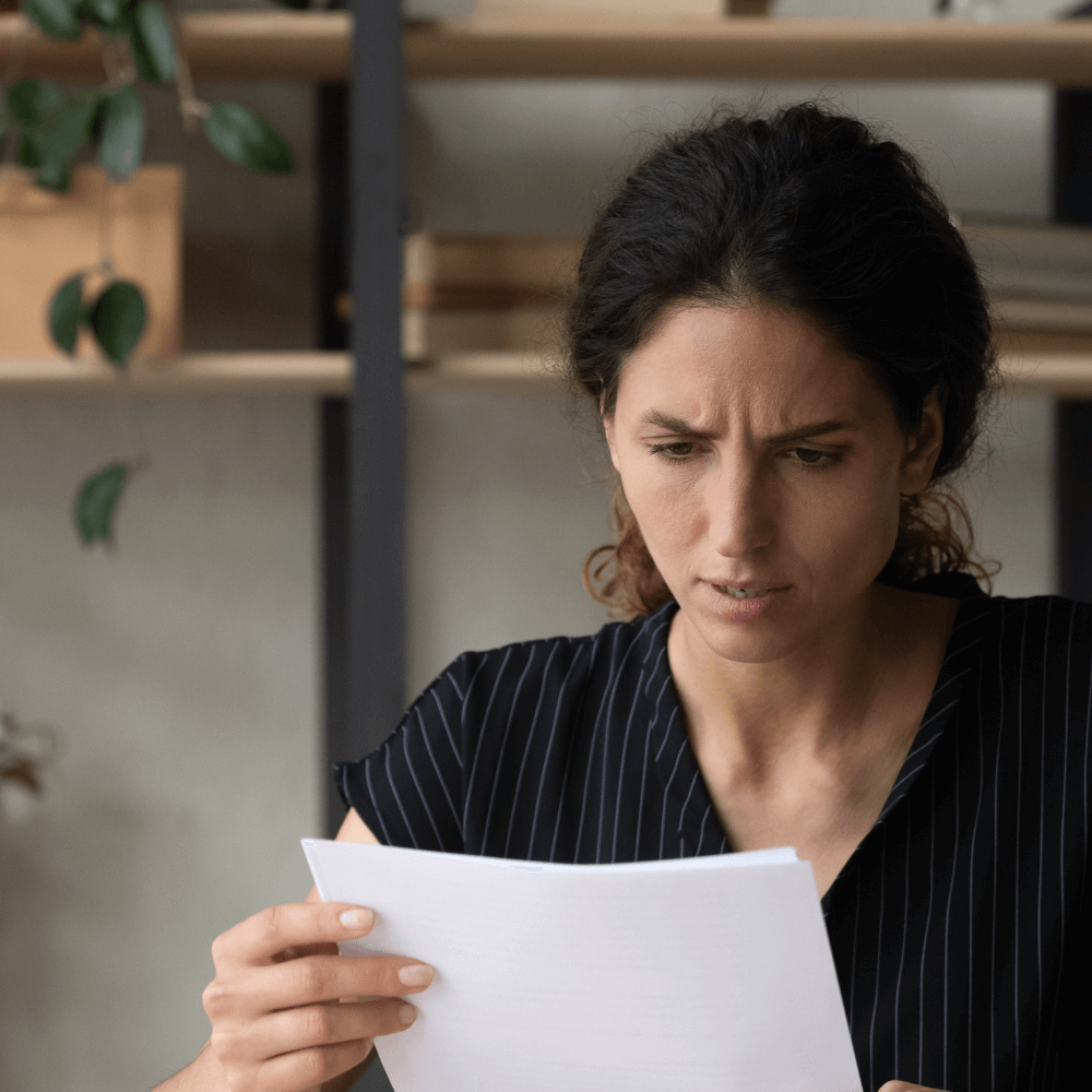 A person reading a letter and looking worried.