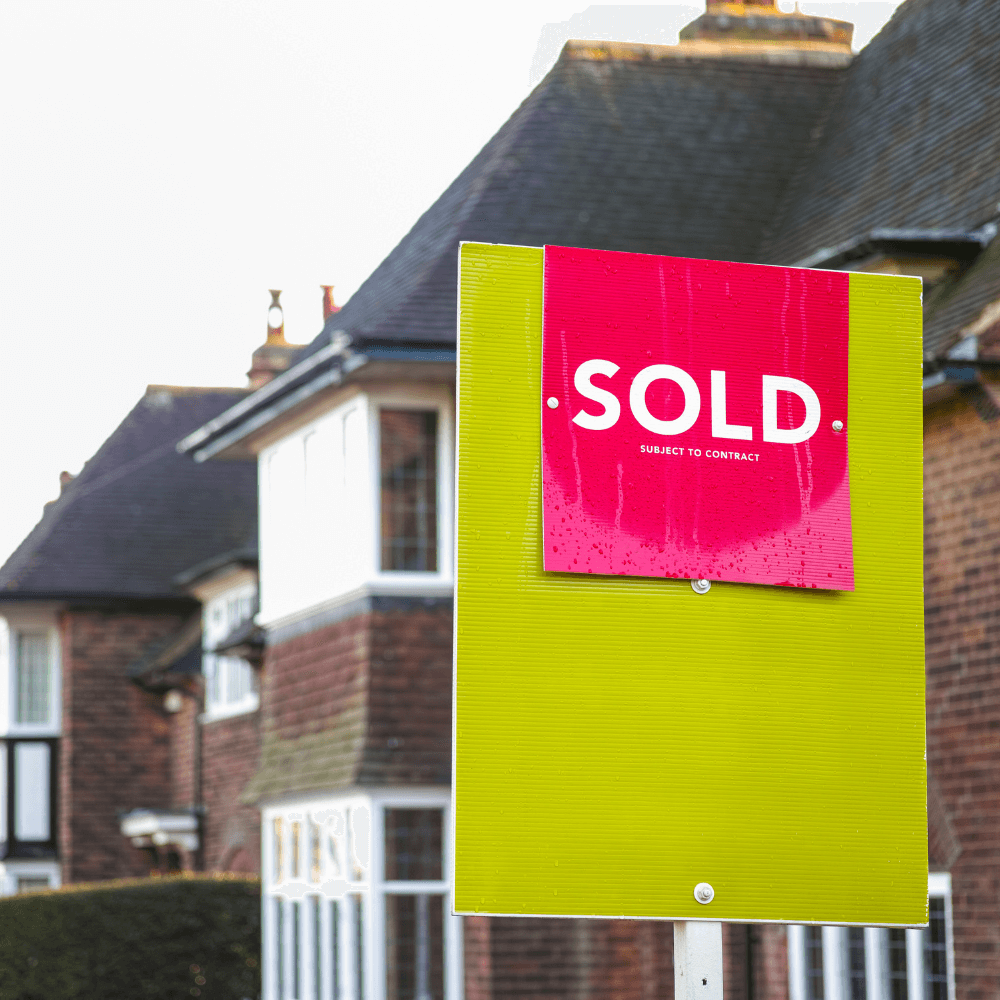 Red sign with 'Sold subject to contract' in white writing.