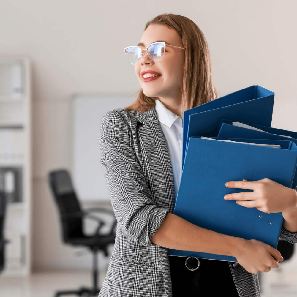 Person holding three blue folders.