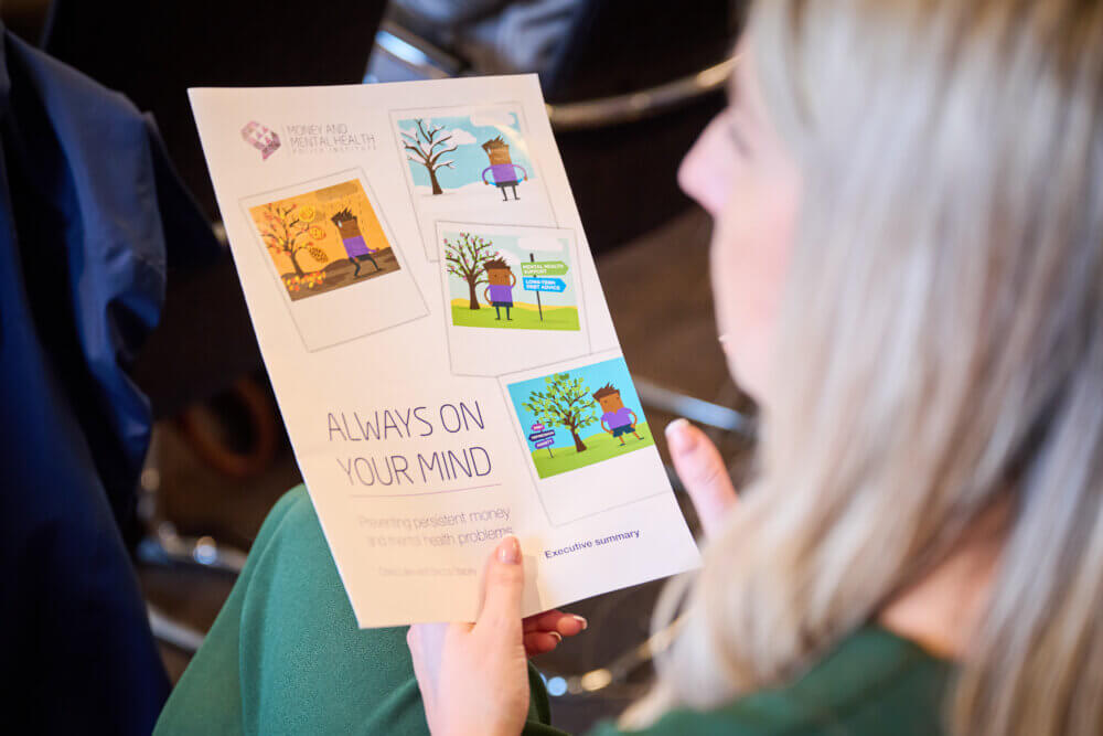 Someone holding a copy of Always on your mind at Money and Mental Health's launch event.