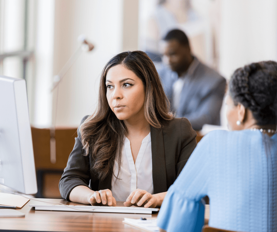 Two people, either side of a desk - representing debt advice taking place.