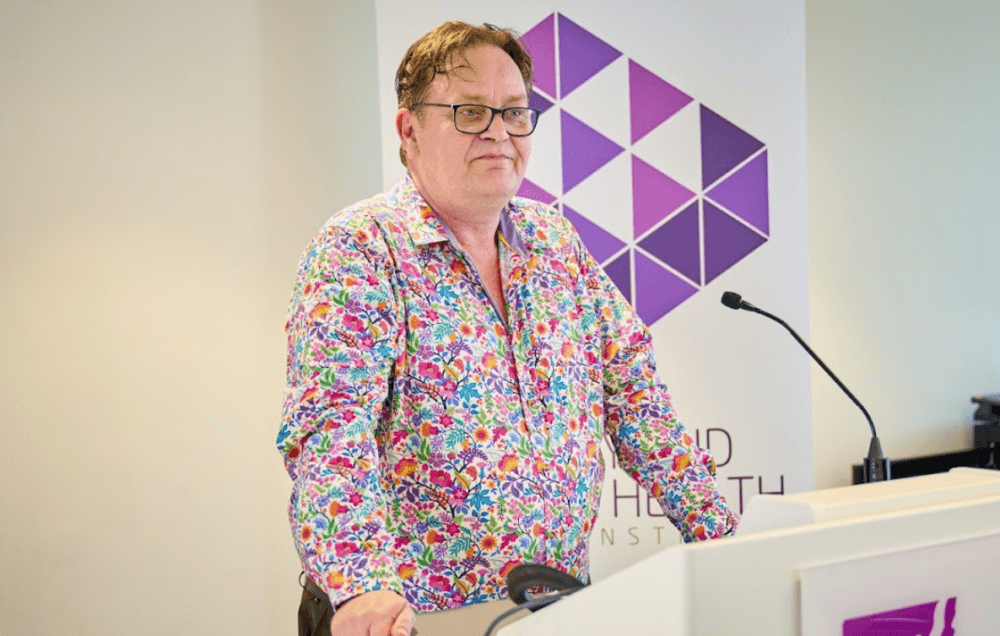 Rob Smale standing at a lectern at Money and Mental Health event.