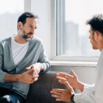 Two men in conversation. One talks while the other listens