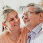 A woman and older man smiling together