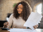 Woman looking at papers and a calculator.