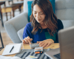 A person budgeting at home, with calculators.