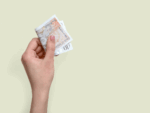 A person holding a £10 note