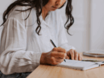 A person budgeting in a small notebook.
