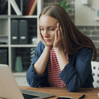A woman looks concerned at her laptop screen