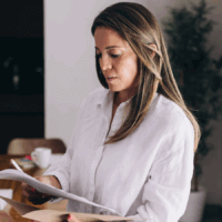 A woman at home holding a letter