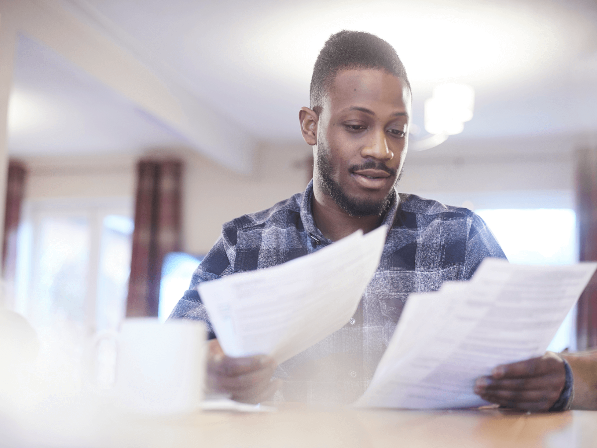 A man looking through papers at a table.