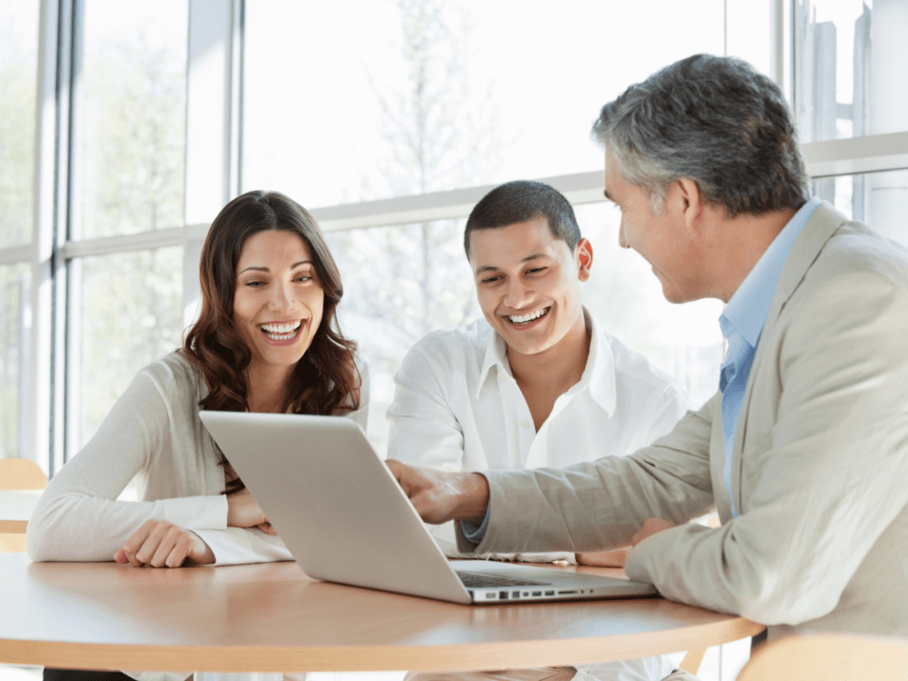 3 people looking at a laptop screen.